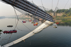 Rescue personnel conduct search operations after a bridge across the river Machchhu collapsed at Morbi in India's Gujarat state on October 31, 2022. At least 130 people were killed in India after a colonial-era pedestrian bridge collapsed, sending scores of people tumbling into the river below, police said on October 31.
