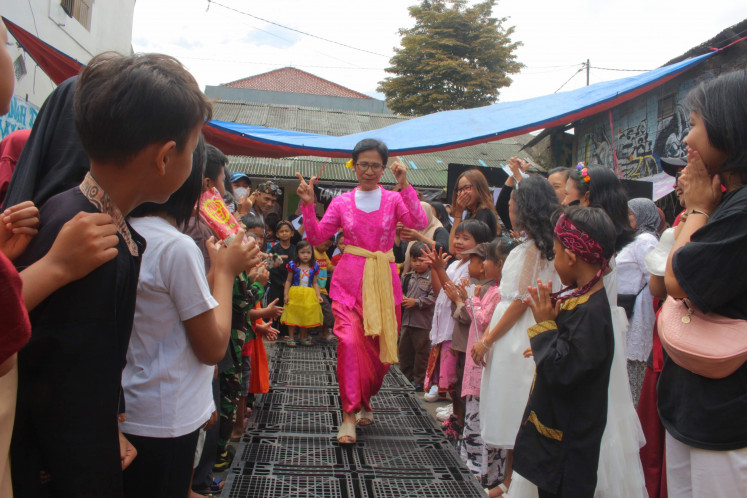 Haute couture: Participating resident walk down the makeshift runway made from lined-up freight pallets during a fashion show at Dago Elos held in celebration of Independence Day on Aug. 17, 2022. (Courtesy Dago Melawan Archive)