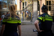 Raising awareness?: Police stand guard outside the Mauritshuis museum after an attempt to smear Johannes Vermeer's painting 'Girl with a Pearl Earring' in The Hague, the Netherlands, on Oct. 27. The Dutch police have arrested three people.