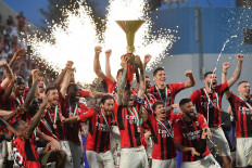 AC Milan's Italian defender Alessio Romagnoli (center) and his team celebrate with the winner's trophy after AC Milan won the Italian Serie A soccer match against Sassuolo, securing the “Scudetto“ championship on May 22 at the Mapei-Citta del Tricolore stadium in Sassuolo, Italy.