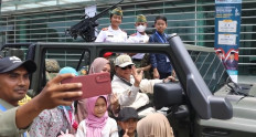Defense Minister Prabowo Subianto (seated, in cap and sunglasses) waves while posing with children on Nov. 5, 2022, the final day of the 2022 Indo Defense Expo & Forum at the Jakarta International Expo in Kemayoran, Central Jakarta, which was open to the public.