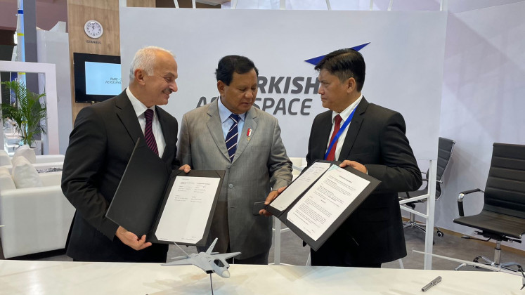 State-owned aircraft maker PT Dirgantara Indonesia president director Gita Amperiawan (right) shows the document to Indonesian Defense Minister Prabowo Subianto (center) while Turkish Aerospace chief executive officer Temel Kotil looks on after the signing of a framework agreement in aerospace engineering program during the 2022 Indo Defense Expo and Forum at the Jakarta International Expo in Kemayoran, Central Jakarta, on Wednesday, Nov. 2, 2022.