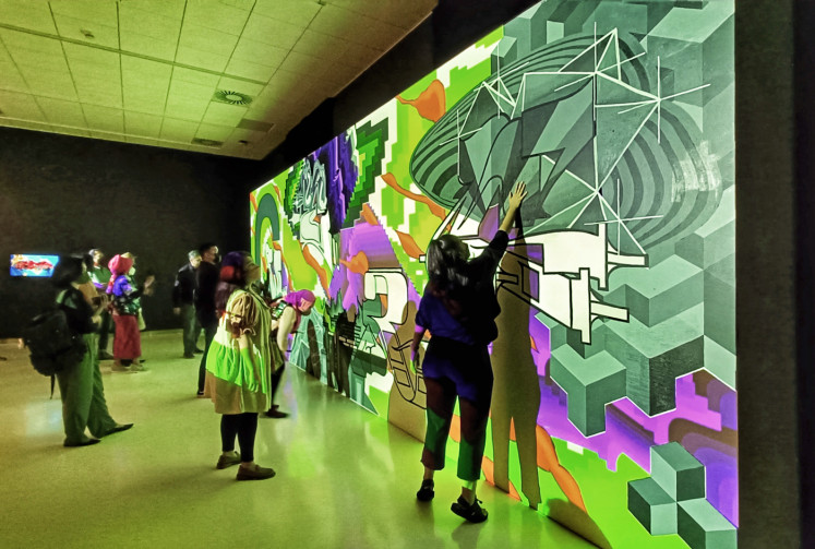 Interactive artwork: Visitors play with 'AR Graffiti' by Dutch artist Jelle Valk, during the opening night on Oct. 12 at Erasmus Huis Jakarta. (JP/Sylviana Hamdani)