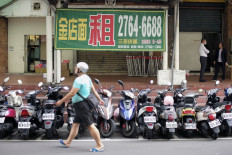 A man walks past advertising for a shoplot for rent along the Zhongxiao East Road, one of Taipei's busier thoroughfares, on Sept. 29, 2022.