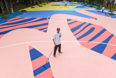 All-rounder street artist: Adi Dharma, better known as Stereoflow, poses on 'Gelora Ragam', the floor mural he is painting on the sports fields at Taman Menteng, Central Jakarta. (Courtesy of Mahavisual)