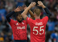 England's Ben Stokes (right) celebrates with teammate Chris Jordan after the wicket of India's captain Rohit Sharma during the ICC men's Twenty20 World Cup 2022 semi-final cricket match England and India at The Adelaide Oval in Adelaide on November 10, 2022. 
