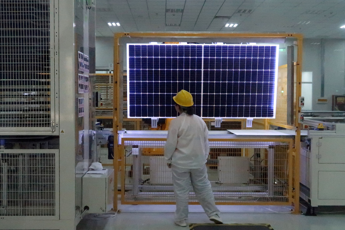 A worker quality-checks a solar module at a factory of solar equipment manufacturer LONGi Green Technology Co, in Xian, China, on Dec. 10, 2019.