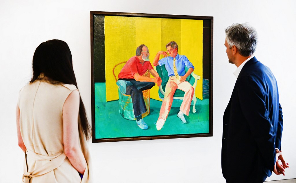 In this file photo taken on October 12, 2022 Christie's senior specialist and senior vice president Alex Marshall (right) views 'The Conversation' by David Hockney on display at Christie's Los Angeles in Beverly Hills, California during the media preview of &ldquo;Visionary: The Paul Allen Collection.&ldquo; Paintings and sculptures from the collection of late Microsoft co-founder Paul Allen were auctioned off for a historic $1 billion Wednesday, Christie's auction house said, with records set for works by Van Gogh, Cezanne, Gauguin, Seurat and Klimt.
