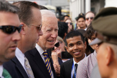 US President Joe Biden greets embassy staff and families at the Phnom Penh International Airport as he arrives to attend the 2022 ASEAN summit in Phnom Penh, Cambodia, Nov. 12, 2022. 