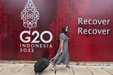 A woman walks past a logo of the G20 Summit, in Jakarta on Nov. 8. 

