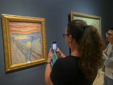 Climate protests: A visitor takes pictures of Edvard Munch's iconic painting The Scream at the National Museum in Oslo. Activists tried on Friday to glue themselves to the painting in protest against Norway's oil industry, but guards intervened and the artwork was not damaged, police said.