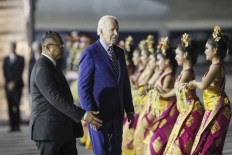 United States President Joe Biden (center) disembarks from Air Force One upon arrival at Ngurah Rai International Airport in Denpasar in Bali, Nov. 13, 2022, as he travels to attend the G20 Summit. 
