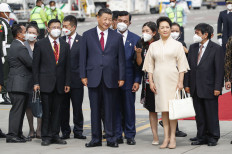 Chinese President Xi Jinping (center) and his wife Peng Liyuan (third right) arrive at Ngurah Rai International airport in Denpasar on the Indonesian resort island of Bali on Nov. 14, 2022. 