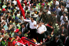 Indonesia president Joko 'Jokowi' Widodo with Vice President Jusuf Kalla stand and wave to residents on a horse-chariot during the parade to the State Palace, Jakarta, Monday (10/20/2014). Jokowi and Jusuf Kalla officially become the 7th president and 12th vice president of the Republic of Indonesia. 
