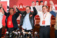 Malaysia's opposition leader Anwar Ibrahim (center) reacts at the end of a press conference in Kuala Lumpur on November 20, 2022.