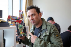 Jason David Frank, from the iconic “Mighty Morphin Power Rangers“, checks out his Limited Edition Tokyo Vinyl Green Ranger at the Power Rangers media suite at San Diego Comic-Con International on July 25, 2014 in San Diego, California, the United States.