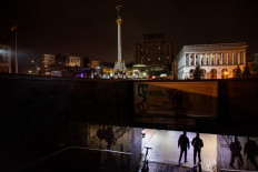Pedestrians walk an underground pass during a power cut at Independence Square in downtown Kyiv on November 10, 2022, amid the Russian invasion of Ukraine.
