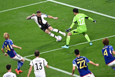 Japan's goalkeeper #12 Shuichi Gonda (right) fouls Germany's defender #03 David Raum during the Qatar 2022 World Cup Group E football match between Germany and Japan at the Khalifa International Stadium in Doha on November 23, 2022. 

