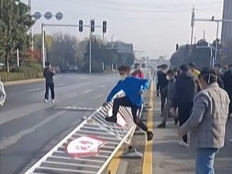 This image grab taken from AFP video footage and posted on November 23, 2022 shows workers at Foxconn’s iPhone factory in Zhengzhou in central China clashing with riot police. Violent protests have broken out around Foxconn's vast iPhone factory in central China, as workers clashed with security personnel over pay and living conditions at the plant.
