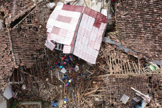 An aerial view shows rescue personnel working to rescue a child from the rubble of a collapsed house at Cugenang in Cianjur, West Java on November 24, 2022, following a 5.6-magnitude earthquake on November 21. 