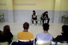 Spanish actors Ana Merchante (L) and Manu Chacon play a scene during interactive theatre by El Teatro Que Cura (The Healing Theatre) to raise awareness about domestic violence among teens, at El Olivo high school in Parla, south of Madrid on November 11, 2022. Set up in 2017, Teatro que Cura uses interactive theatre to immerse teens in dramatised scenarios of inequality and violence to raise awareness about conflict and gender-based violence.
