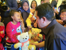 State-Owned Enterprises (SOEs) Minister Erick Thohir hands a BNI teddy bear to a child at the Medical and Trauma Healing center in Cianjur on Friday.