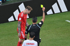 Guatemalan referee Mario Escobar shows a yellow card to Wales' defender #06 Joe Rodon during the Qatar 2022 World Cup Group B football match between Wales and Iran at the Ahmad Bin Ali Stadium in Al-Rayyan, west of Doha on November 25, 2022. 
