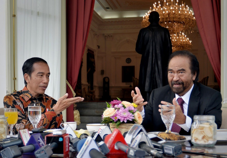 President Joko “Jokowi“ Widodo (left) and NasDem Party chairman Surya Paloh talk during a meeting on Nov. 22, 2018. 