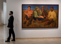 A gallery assistant stands near 'Rest' by Oleksandr Syrotenko during the press preview of 'In the Eye of the Storm' an exhibition on Ukrainian avant-garde art in the first decades of the 20th century at the Thyssen-Bornemisza museum in Madrid on November 28, 2022.