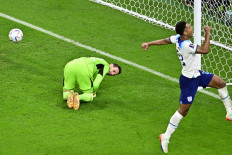 England's forward #11 Marcus Rashford (right) celebrates scoring his team's first goal from a free-kick past Wales' goalkeeper #12 Danny Ward (left) during the Qatar 2022 World Cup Group B football match between Wales and England at the Ahmad Bin Ali Stadium in Al-Rayyan, west of Doha on November 29, 2022. 
