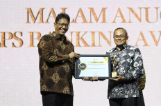(Left to right) LPS board of commissioners head Purbaya Yudhi Sadewa and BNI human capital and compliance head Mucharom display an award at the 2022 LPS Banking Awards in Jakarta on Tuesday. BNI was granted awards in three categories: the best bank in delivering LPS insurance programs with the most active role in education, the most active bank in green banking practices and the most active bank in corporate social responsibility (CSR) programs.