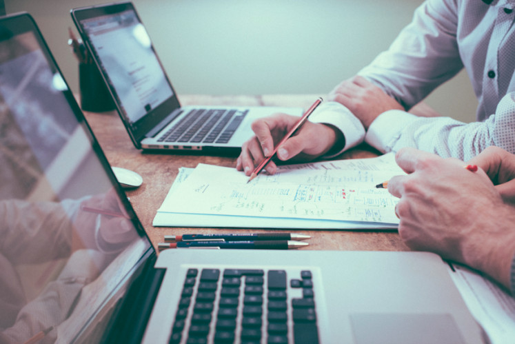 Overachievers vs quiet quitters: Pictured is an illustration of employees discussing work. According to human resources practitioner Kiara, miscommunication with coworkers can be a prominent cause for quiet quitting, as people's expectations clash with the reality. (Unsplash/Scott Graham)