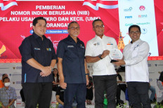 Erick Thohir, State-Owned Enterprises (SOEs) Minister (left), attends an event for the Acceleration of Distribution for Business Identification Numbers (NIB) on Thursday in Lampung. The event was supported by various stakeholders, including the regional 
