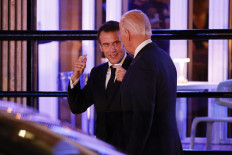 French President Emmanuel Macron (left) chats with United States President Joe Biden as they leave Fiola Mare restaurant after a private dinner in Washington, DC, on Nov. 30, 2022.