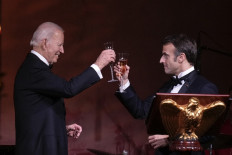 US President Joe Biden and French President Emmanuel Macron make a toast after speaking at the state dinner on the South Lawn of the White House on December 1, 2022 in Washington, DC. President Biden is hosting Macron for the first official state visit of the Biden administration. 
