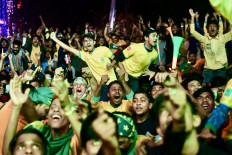 Soccer fans celebrate as Brazil scores a goal while watching the Qatar 2022 World Cup Round of 16 football match between Brazil and South Korea on a big screen in Dhaka, on Dec. 6, 2022.