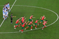 Morocco's players celebrate at the end of the Qatar 2022 World Cup round of 16 football match between Morocco and Spain at the Education City Stadium in Al-Rayyan, west of Doha on December 6, 2022. 