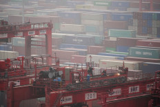 Workers man a container crane on Jan. 13, 2022 at Yangshan Deep Water Port in Shanghai, China.