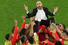 Morocco's players throw Morocco's coach Walid Regragui in the air as they celebrate at the end of the Qatar 2022 World Cup round of 16 football match between Morocco and Spain at the Education City Stadium in Al-Rayyan, west of Doha on December 6, 2022. 
