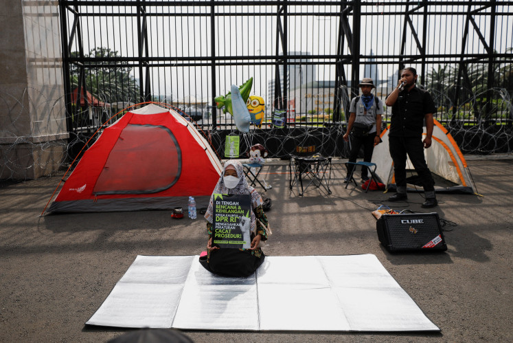 Activists take part in a protest after the House of Representatives approved a new criminal code that will ban sex outside marriage, cohabitation between unmarried couples, insulting the president, and expressing views counter to the national ideology, outside the House buildings in Jakarta, Indonesia, December 6, 2022. 
