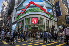 Pedestrians walk past a Hang Seng branch in Hong Kong on October 28, 2022. Hundreds of top bankers will take part in a summit in Hong Kong next week as the city prepares to reopen for business after the pandemic.