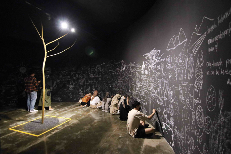 Manifesting through sketches: Pictured is Prilla Tania's participative installation, “Asa” (2022), where visitors can contribute their drawings around the walls surrounding the tree trunk that is placed in the middle of the room. (Courtesy of Selasar Sunaryo Art Space)