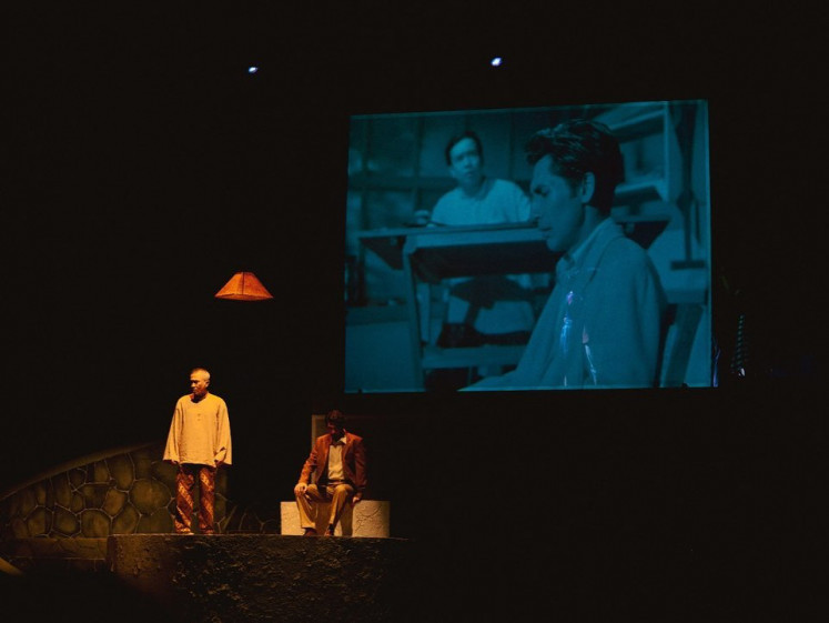 Past and present: Actors Lukman Sardi (left) and Reza Rahadian perform a scene in the 1954 film 'Lewat Djam Malam', which is also projected on the screen behind. 