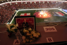 A tribute for US journalist Grant Wahl, who died after he collapsed in the stadium's press area while covering the match between Argentina and Netherlands, can be seen in the media tribune ahead of the Qatar 2022 World Cup quarter-final football match between England and France at the Al-Bayt Stadium in Al Khor, north of Doha, on Dec.10, 2022. 