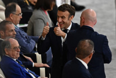 French President Emmanuel Macron (center) gives thumbs-up as he attends the Qatar 2022 World Cup semi-final football match between France and Morocco at the Al-Bayt Stadium in Al Khor, north of Doha on December 14, 2022. 
