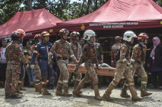 Fire and rescue department workers carry out the body of a victim after a landslide in Batang Kali, Selangor on December 16, 2022. At least 16 people were killed when a landslide struck a campsite at a Malaysian farm on December 16, 2022, officials said, with rescuers scouring the muddy terrain for nearly 20 people still missing.

