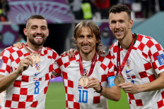 (Left-right) Croatia's midfielder #08 Mateo Kovacic, Croatia's midfielder #10 Luka Modric and Croatia's midfielder #04 Ivan Perisic celebrate with their medals after winning the Qatar 2022 World Cup third place play-off football match between Croatia and Morocco at Khalifa International Stadium in Doha on December 17, 2022. 
