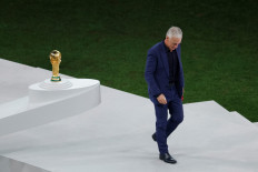 France's coach Didier Deschamps walks past the FIFA World Cup Trophy after receiving a silver medal during the Qatar 2022 World Cup trophy ceremony after the football final match between Argentina and France at Lusail Stadium in Lusail, north of Doha on December 18, 2022. Argentina won in the penalty shoot-out. 
