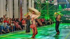 Trend forecast: A model wears garments from Jarum Hijau by Ali Charisma. Crop tops, asymmetrical skirts and boots are expected to be trendy this year.