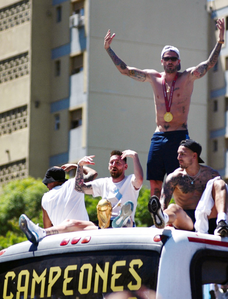 Argentina’s Lionel Messi, Rodrigo De Paul, Leandro Paredes and teammates celebrate on a bus with the World Cup trophy during a victory parade in Buenos Aires on Dec. 20, 2022.